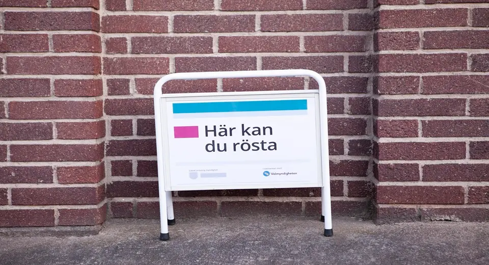 Skylt utanför röstningslokal med texten: här kan du rösta.