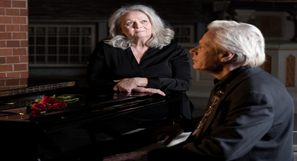 Ulf Esborn sitter vid ett piano. Marie Arturén står bredvid.