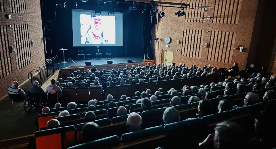 en välfylld sal där film visas