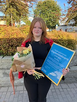 En tjej som håller ett diplom