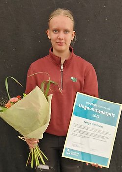 En tjej som håller ett diplom