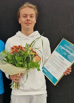 En kille som håller ett diplom