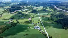 Flygfoto över åkrar, väg, bebyggelse